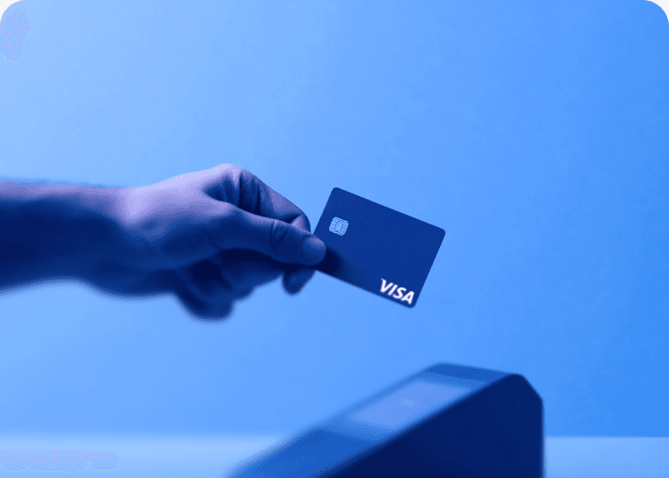 Hand tapping a Visa card on a payment terminal